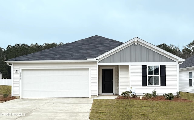 ranch-style house with an attached garage, roof with shingles, concrete driveway, and a front yard