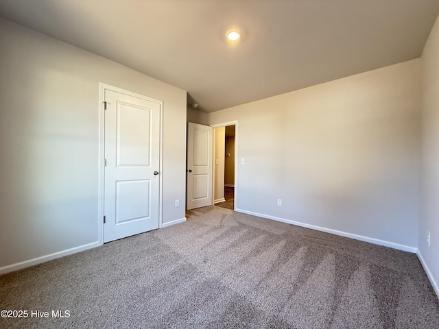 unfurnished bedroom with carpet floors and baseboards