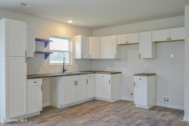 kitchen featuring hardwood / wood-style floors, white cabinetry, and sink