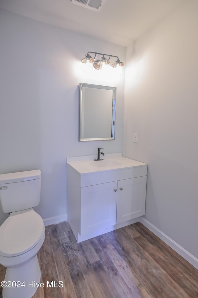 bathroom featuring hardwood / wood-style floors, vanity, and toilet