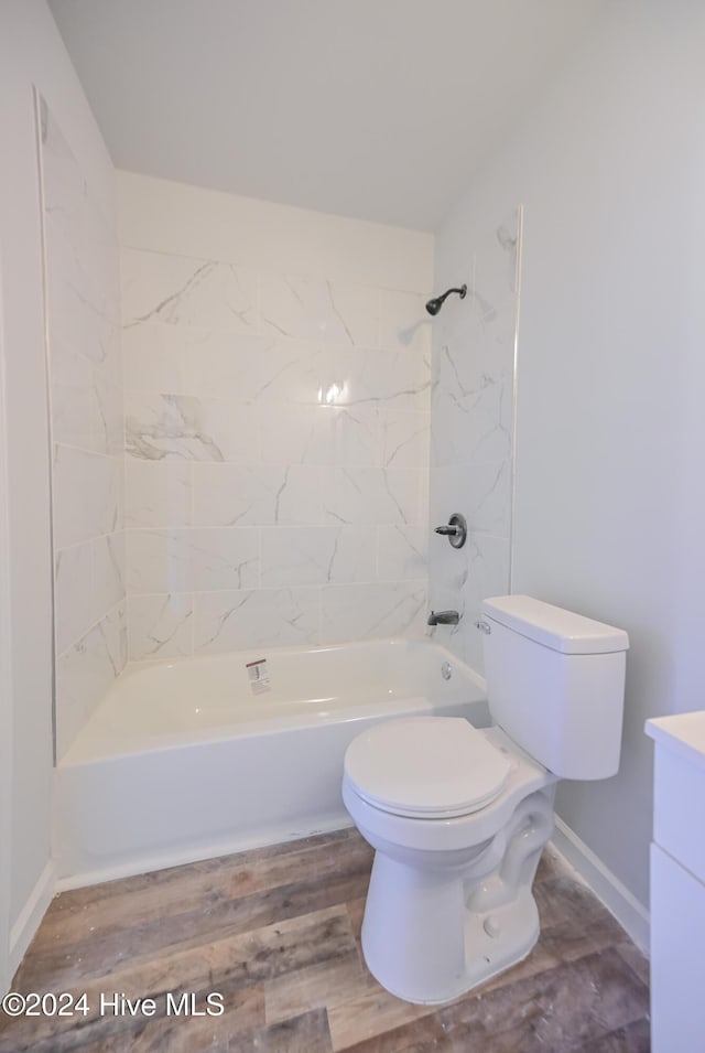 full bathroom with toilet, vanity, hardwood / wood-style floors, and washtub / shower combination