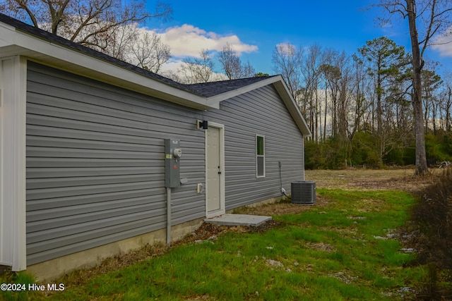 view of property exterior with a yard and central air condition unit