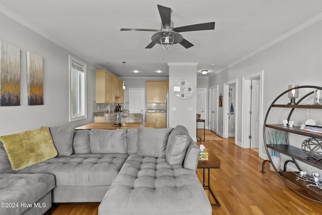 living room featuring light hardwood / wood-style floors, ceiling fan, and crown molding