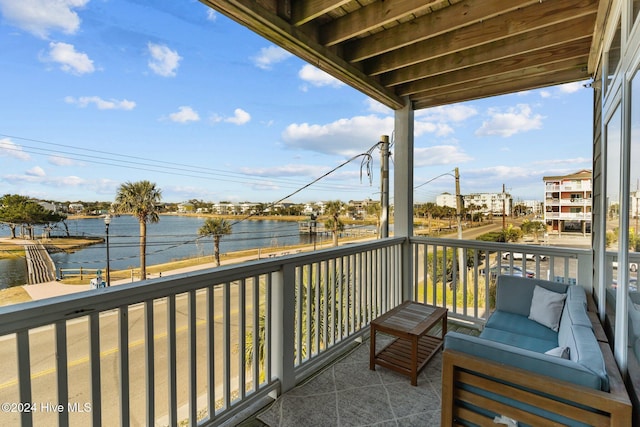 balcony featuring outdoor lounge area and a water view