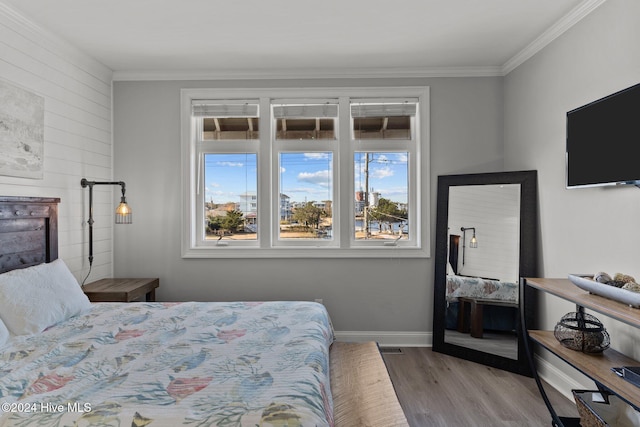 bedroom with hardwood / wood-style floors and ornamental molding