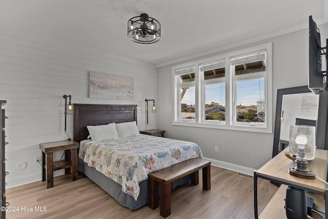 bedroom with light hardwood / wood-style floors and crown molding