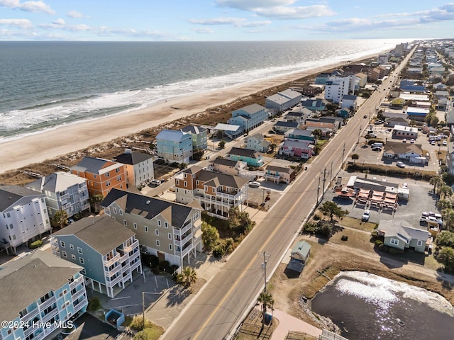 birds eye view of property with a water view and a beach view