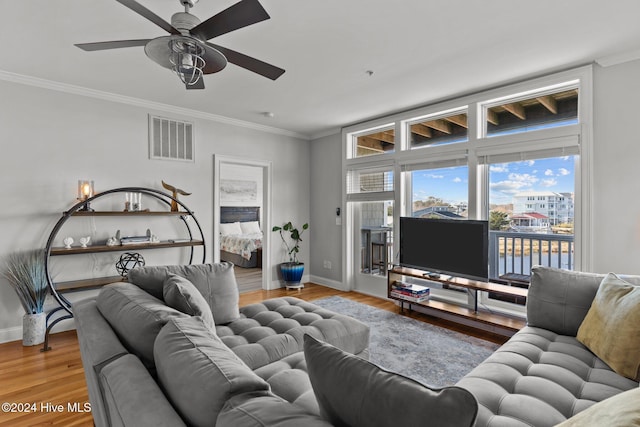 living room featuring crown molding, hardwood / wood-style floors, and ceiling fan