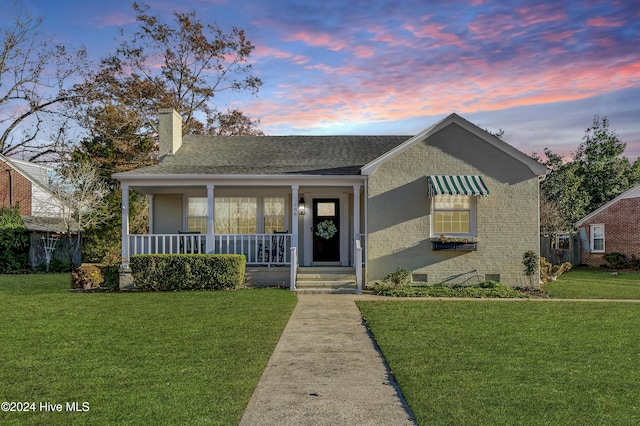 bungalow-style house featuring a lawn and covered porch