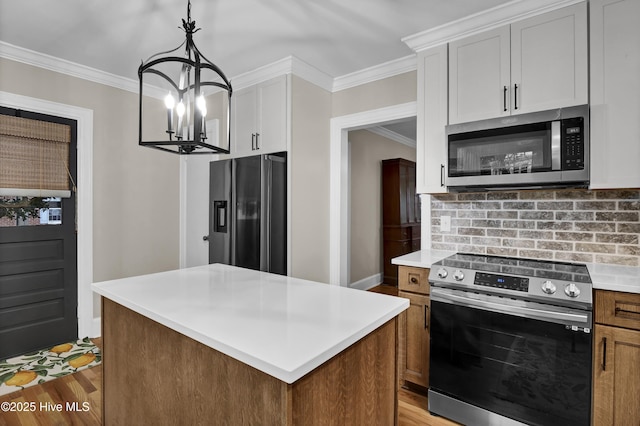 kitchen featuring light countertops, appliances with stainless steel finishes, white cabinetry, crown molding, and light wood-type flooring