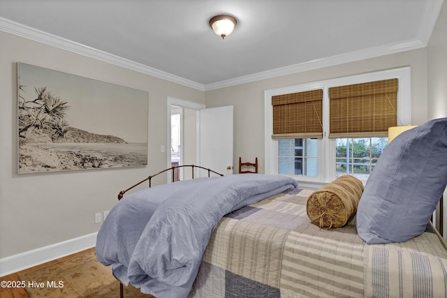 bedroom featuring wood finished floors, baseboards, and ornamental molding