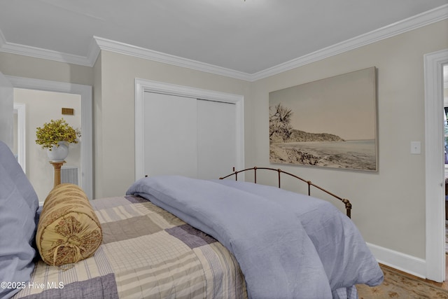 bedroom featuring wood finished floors, a closet, baseboards, and ornamental molding