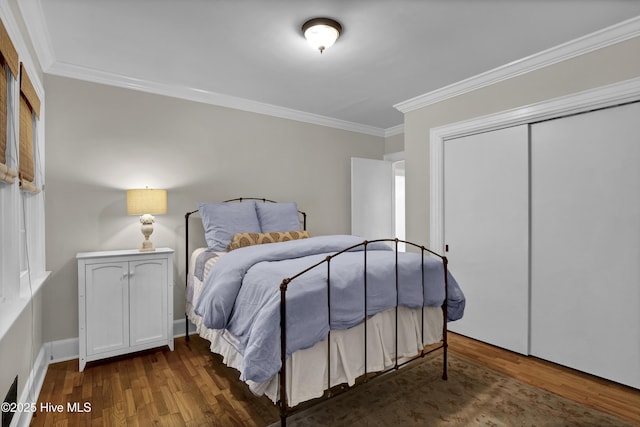 bedroom featuring wood finished floors, a closet, and ornamental molding