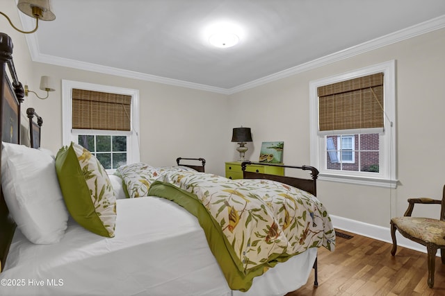 bedroom featuring baseboards, wood finished floors, and ornamental molding