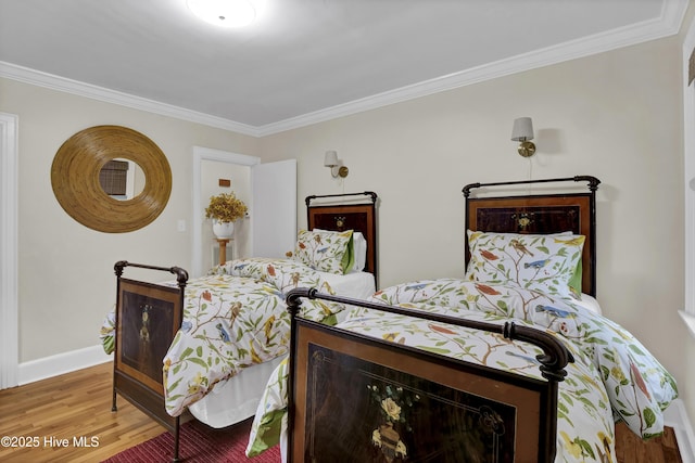 bedroom featuring baseboards, wood finished floors, and ornamental molding