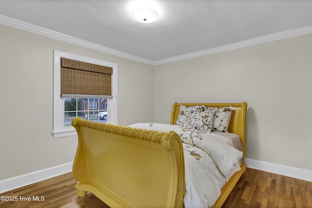 bedroom featuring crown molding, wood finished floors, and baseboards