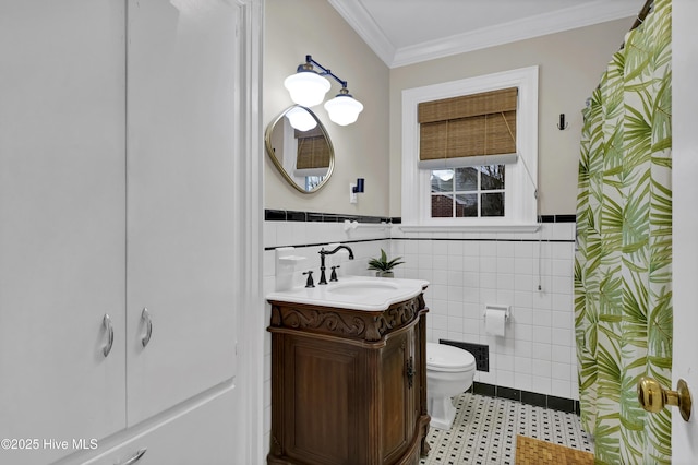 full bath with a wainscoted wall, toilet, tile walls, crown molding, and vanity