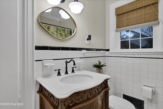 bathroom featuring tile walls, toilet, and vanity