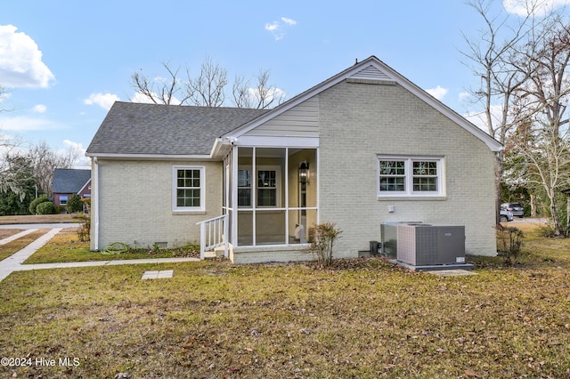 view of front of property featuring a front lawn, cooling unit, a sunroom, crawl space, and brick siding