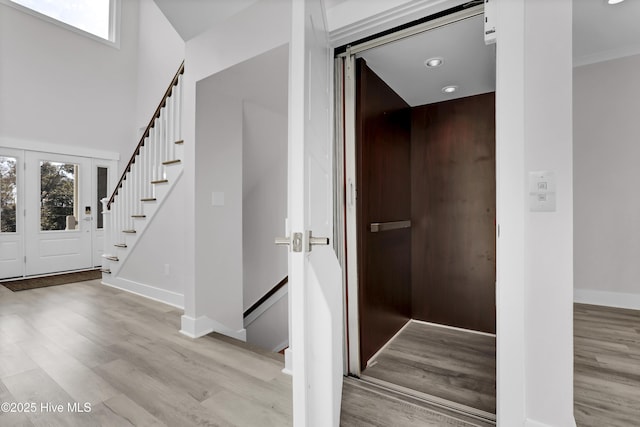 staircase with elevator, hardwood / wood-style floors, and a wealth of natural light