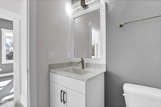 bathroom with vanity, toilet, and a wealth of natural light