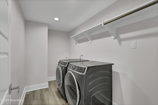 clothes washing area featuring independent washer and dryer and hardwood / wood-style floors