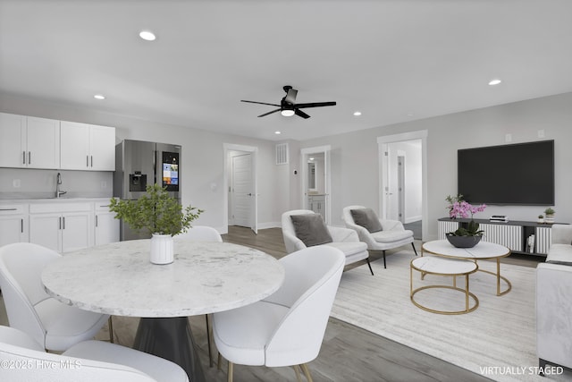 dining room featuring ceiling fan, dark hardwood / wood-style floors, and sink