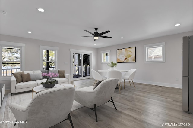 living room with light hardwood / wood-style flooring and ceiling fan