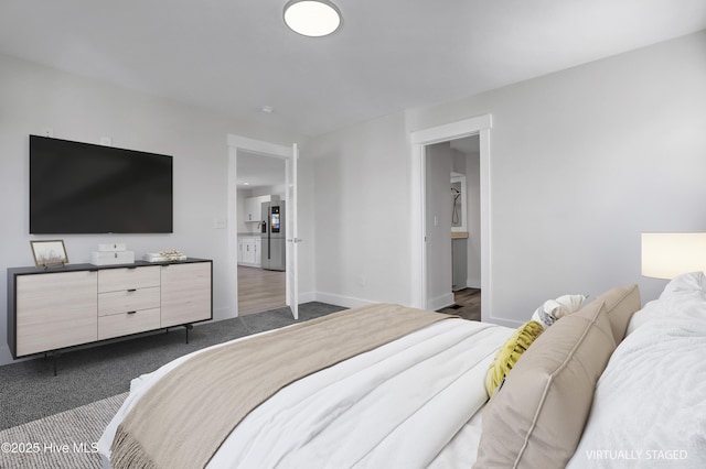 carpeted bedroom featuring stainless steel refrigerator