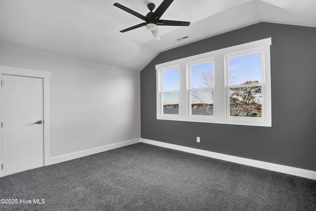 additional living space featuring ceiling fan, lofted ceiling, and dark colored carpet