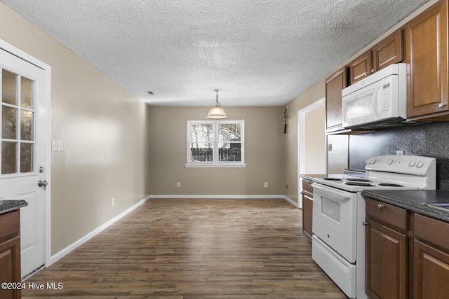 kitchen with dark hardwood / wood-style floors, dark stone countertops, a textured ceiling, decorative light fixtures, and white appliances