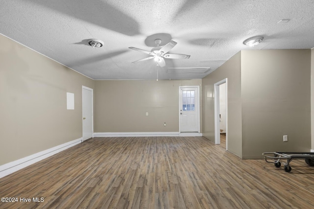 unfurnished room with a ceiling fan, a textured ceiling, baseboards, and wood finished floors