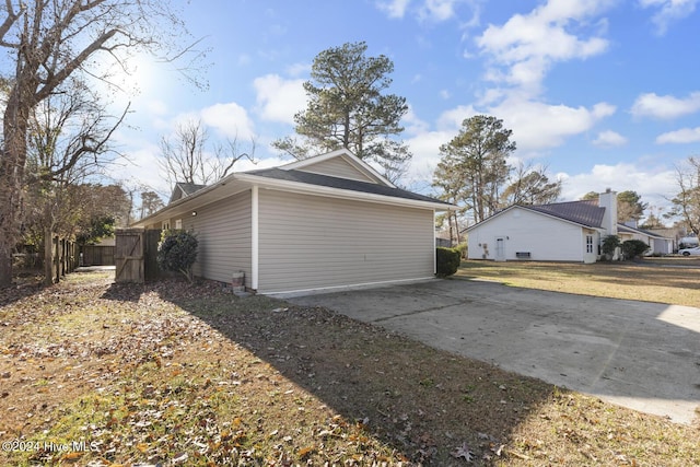 garage featuring driveway and fence