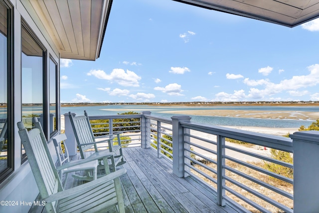 deck featuring a view of the beach and a water view