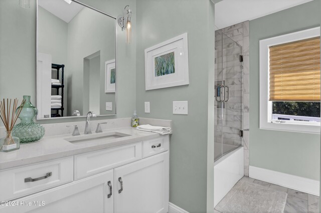 bathroom featuring enclosed tub / shower combo and vanity