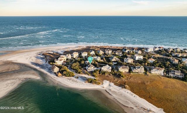 aerial view at dusk featuring a beach view and a water view