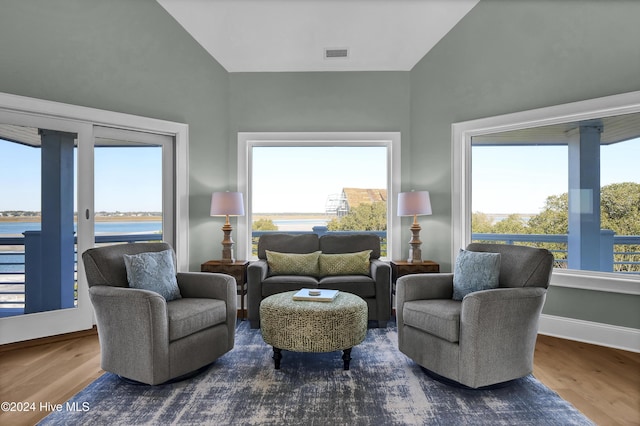 living area with hardwood / wood-style flooring, plenty of natural light, and a water view