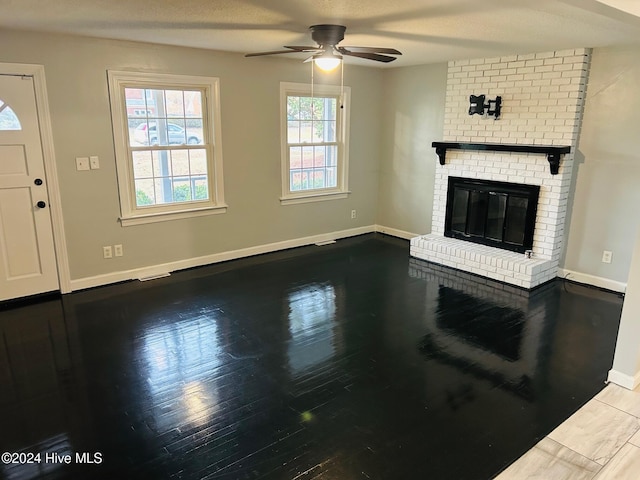 unfurnished living room featuring a fireplace, ceiling fan, hardwood / wood-style floors, and a textured ceiling