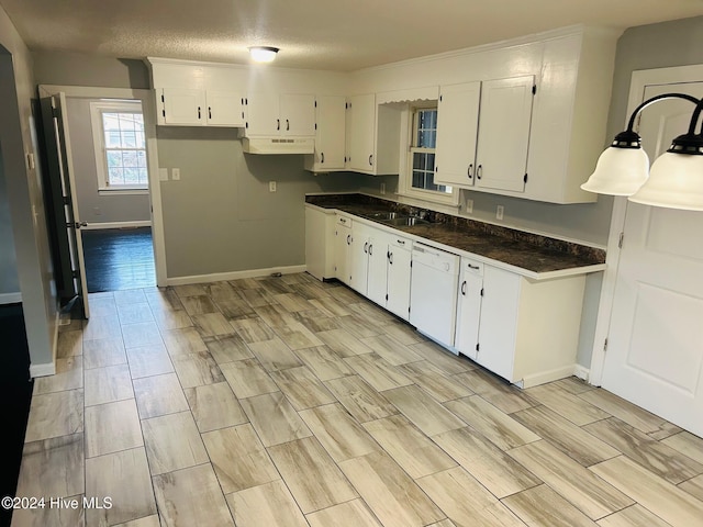 kitchen featuring dishwasher, white cabinets, sink, dark stone countertops, and a textured ceiling