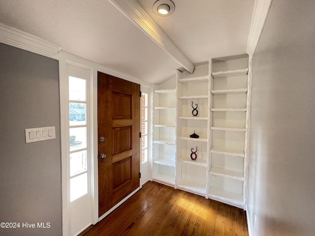 entrance foyer featuring a textured ceiling, dark hardwood / wood-style floors, vaulted ceiling, and crown molding