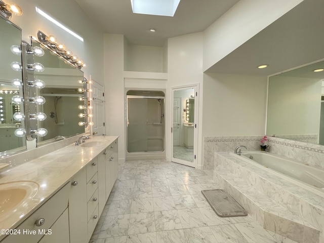 bathroom with a skylight, vanity, independent shower and bath, and a high ceiling