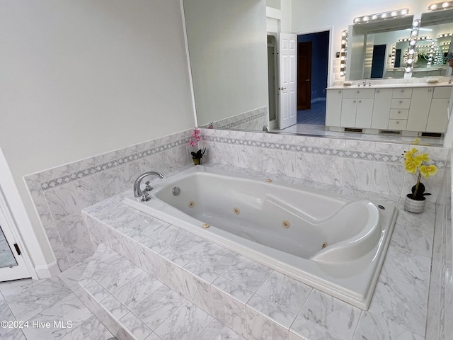 bathroom featuring vanity and a relaxing tiled tub