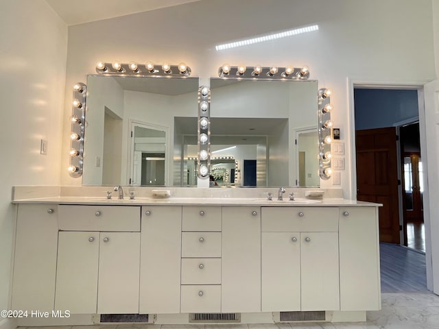 bathroom with vanity, wood-type flooring, and vaulted ceiling