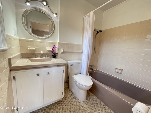 full bathroom featuring shower / bath combo with shower curtain, vanity, tile walls, and toilet