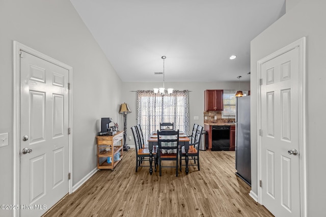 dining area featuring light wood-type flooring and a chandelier