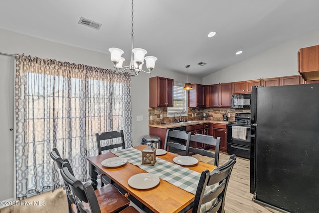 dining area with sink, an inviting chandelier, light wood-type flooring, and lofted ceiling