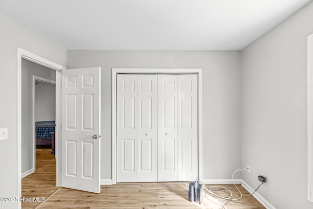 unfurnished bedroom featuring hardwood / wood-style floors and a closet