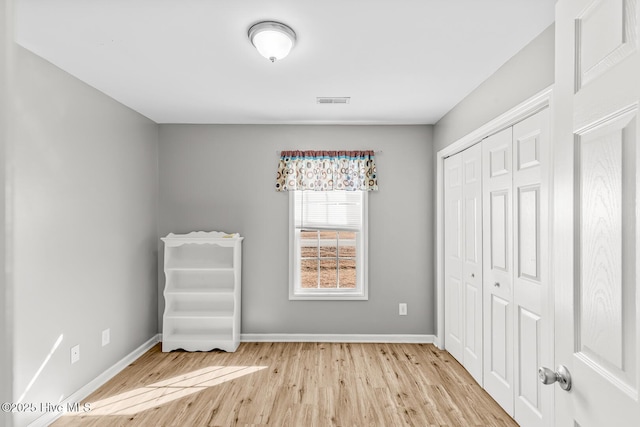 unfurnished bedroom featuring light hardwood / wood-style floors and a closet