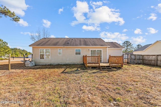 back of property featuring a wooden deck and a yard