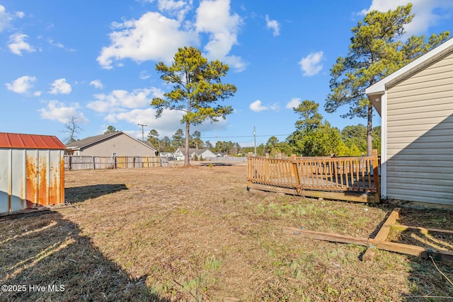 view of yard featuring a deck and a storage shed